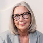 Portrait of an elegant senior woman with glasses on a white background.