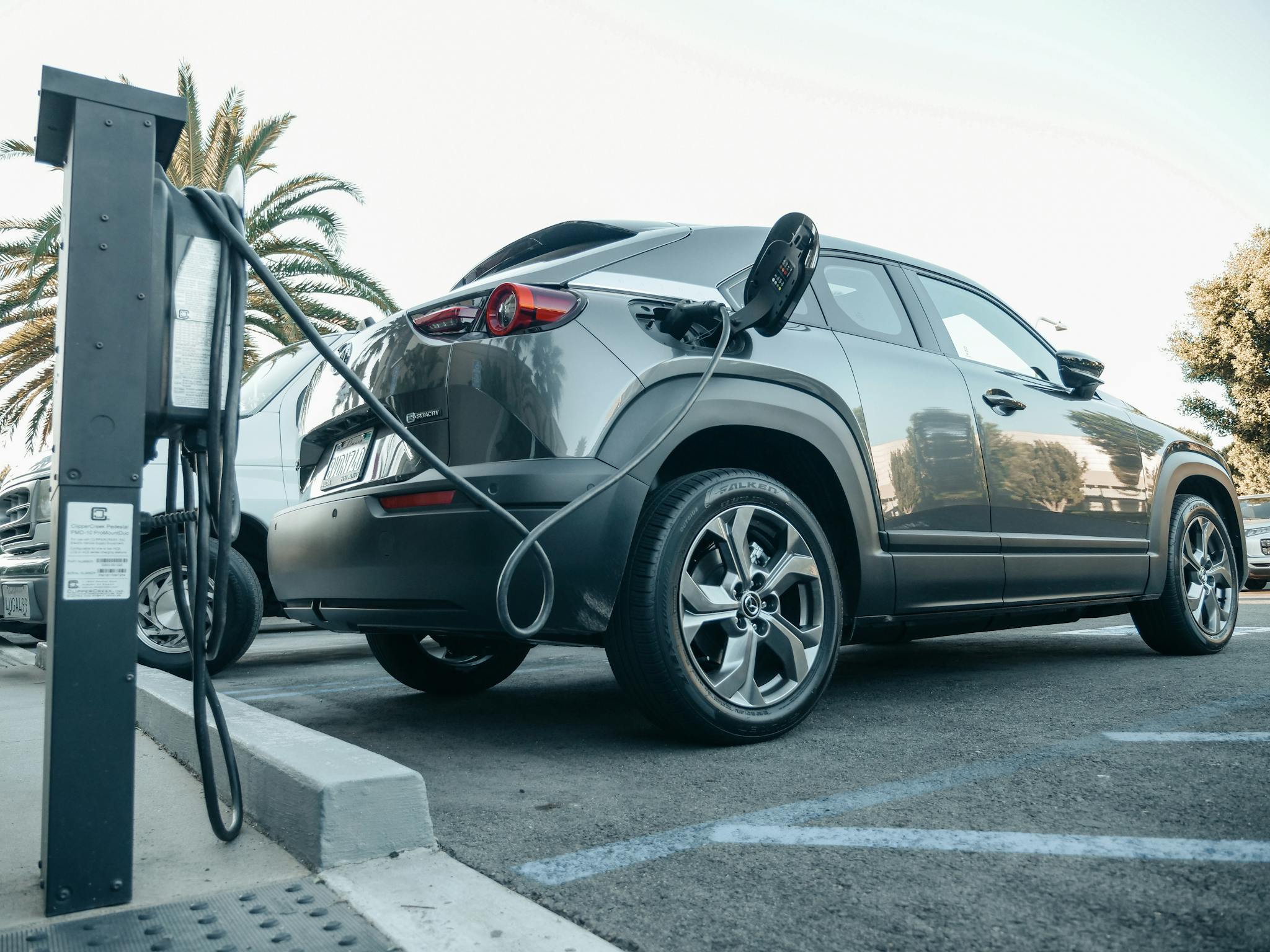 Modern electric vehicle charging at an outdoor station in daylight.